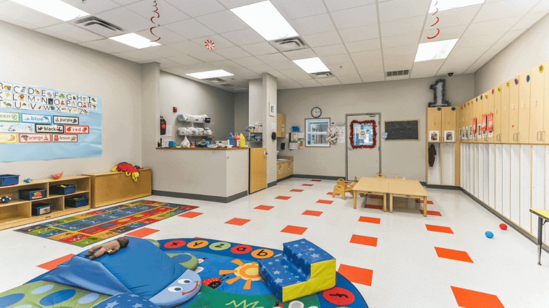 Colorful preschool classroom with toys, lockers, and learning areas.
