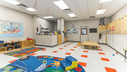 Colorful preschool classroom with toys, lockers, and learning areas.